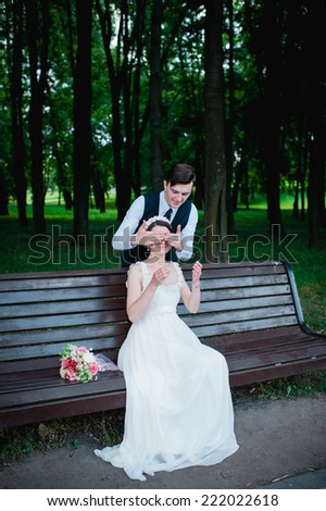 Wedding shot of bride and groom in park. summer nature outdoor. Beautiful bride and groom is enjoying his wedding day.  They kiss and hug each other