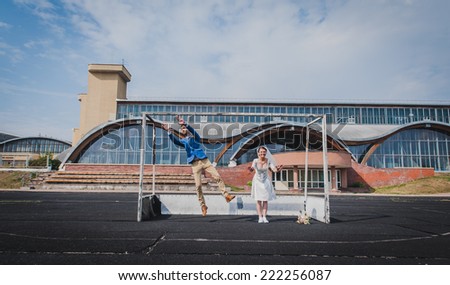 Funny Bride and groom posing on the football field