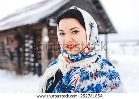 beautiful woman in a fur coat and scarf.  Russian village. Winter.