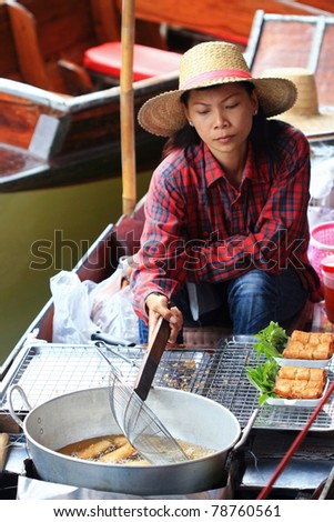 RATCHABURI, THAILAND - JULY 5: Local people sell food items at Damnoen Saduak floating market on July 5, 2009 in Ratchaburi, Thailand. Damnoen Saduak is a very popular tourist attraction.
