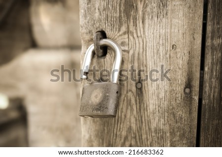 Open padlock on an old wooden door