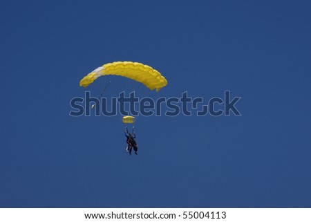 A yellow skydive (tandem) parachute against a blue sky
