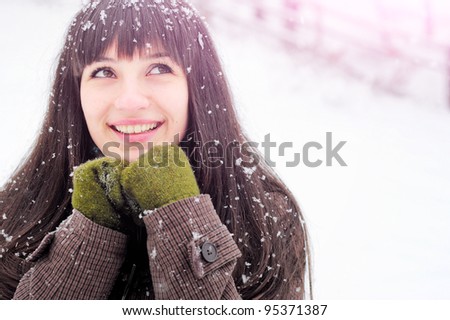 Happy woman in snow looking upwards