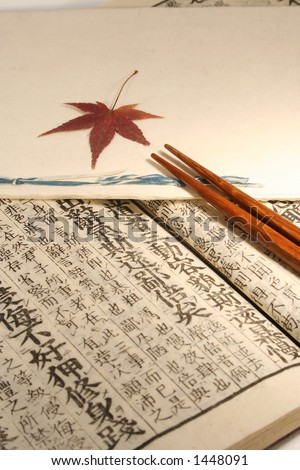 Old Japanese book from meiji period with chopsticks and japanese maple leaf
