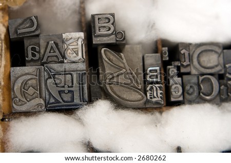 Metal type blocks, used for letterpress printing. Mixed type in a wooden tray with cotton wool packing.