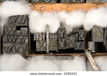 Metal type blocks, used for letterpress printing. Mixed type in a wooden tray with cotton wool packing.