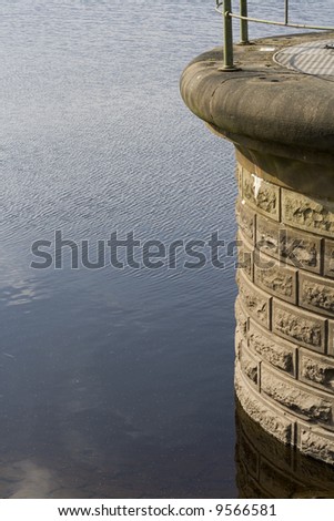 Reservoir details water and brickwork, with metal railings. Taken at Ogden water reservoir in West Yorkshire.