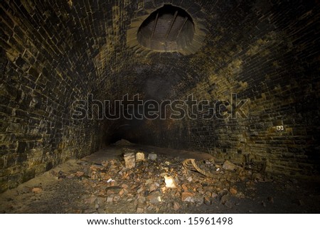Dark Tunnel ventilation shaft. Underground Light painting in disused railway tunnels, darkness creatively lit with torches.