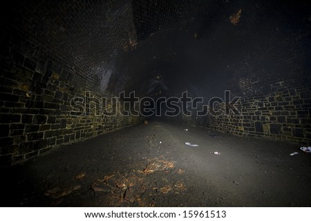 Dark misty and Underground Light painting in disused railway tunnels, darkness creatively lit with torches.