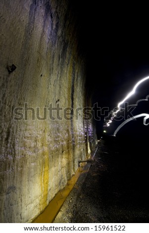 Calcification coming from the lime mortar in the brickwork of the disused tunnel walls. Underground Light painting, darkness creatively lit with torches.
