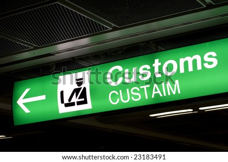 Customs sign in Airport and direction arrow, green and lighted.