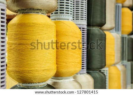 Yellow and gray silk thread roll in silk spool