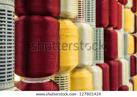 Red and yellow silk thread roll in silk spool