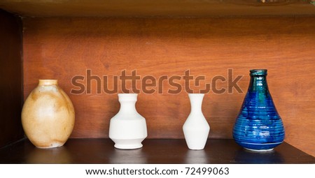 four earthenwares on wooden shelf in still-life style