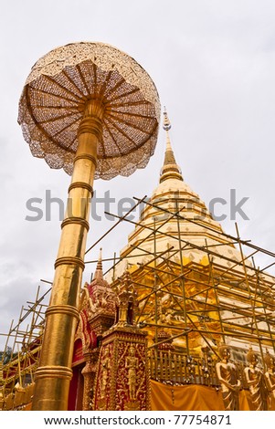 Golden pagoda of wat doi suthep with golden umbrella in front left