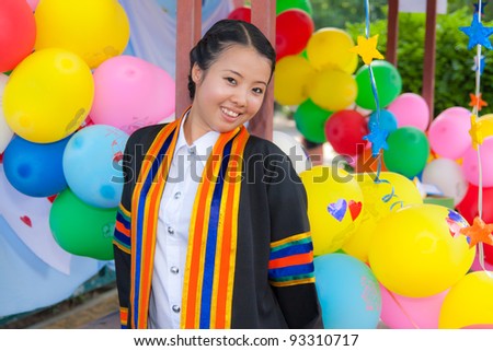 Graduated Asian girl with  colorful balloons in background