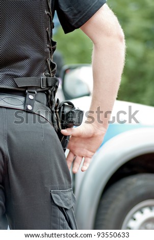 Policeman with the gun, police car in the background