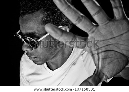 Young African American with his hand up looking away with focus on face