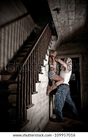 Horror scene of a woman being held off the ground and choked by hooded man.