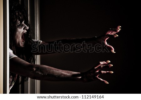 Horror Scene of a Zombie or Woman Possessed Grabbing out of Doorway