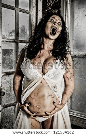 Horror Scene of a Pregnant Woman Possessed with cracked skin holding her belly with baby face impression pushing through her abdomen.