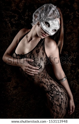 Sexy Young Woman wearing a silver mask and lace body suit.