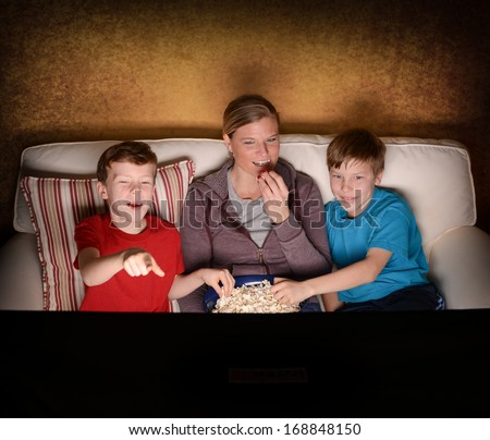 Mother and her two boys watching a comedy Movie at home