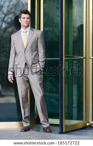 Handsome Business Man Standing Beside Revolving Doors
