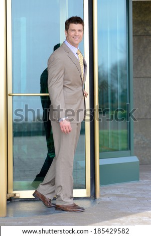 Handsome Business Man Smiling Leaving through Revolving Doors