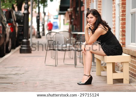 Attractive woman sitting on bench downtown