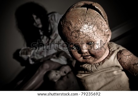Creepy Doll with Possessed Woman holding doll parts in the background focus is on Doll