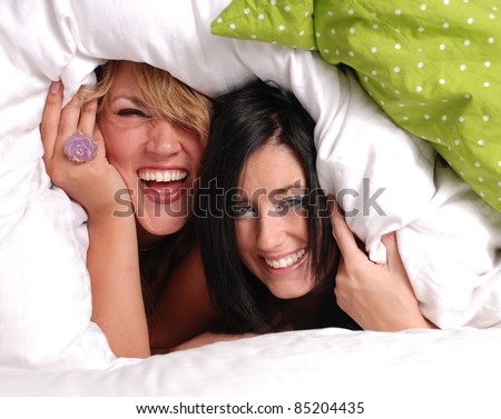 Two girls playing in the bed under the covers (Room Mates)