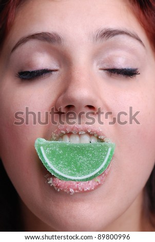 Young Woman Biting into a candy lime with Candy lips