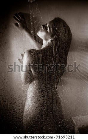 Beautiful Woman Taking a Hot Shower focus on glass - stock photo