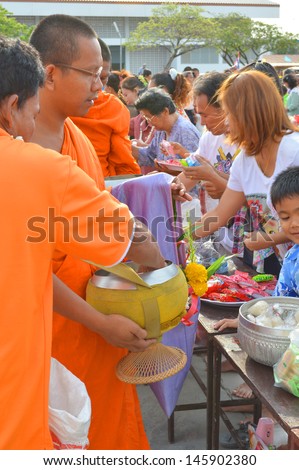 MAHASARAKHAM, THAILAND - APRIL 13 : Unidentified people are giving food offering to monks in Thai New Year Festival on April 13, 2013 in City Hall Plaza, Payakkaphumphisai, Mahasarakham, Thailand.