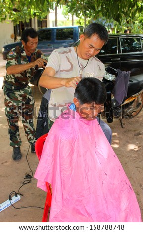MAHASARAKHAM - OCTOBER 17 : Unidentified man is getting a haircut by hairdresser in public healthy mobile project at Non Mi village on October 17, 2013 in Mahasarakham, Thailand.