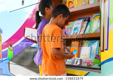 MAHASARAKHAM, THAILAND - OCTOBER 17 : Unidentified children aged 10-12 years select a book for reading from mobile public library at Non Mi village on October 17, 2013 in Muang Mahasarakham, Thailand.