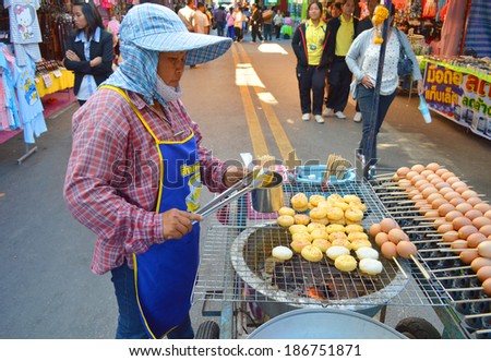 MAHASARAKHAM - JANUARY 29 : Merchant woman is selling food at open market zone of red cross fair on January 29, 2014 in Mahasarakham, Thailand.