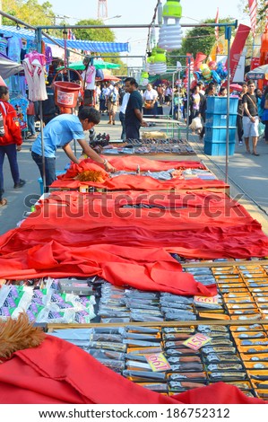 MAHASARAKHAM - FEBRUARY 3 : Merchant man is selling souvenirs at open market zone of red cross fair on February 3, 2014 in Mahasarakham, Thailand.