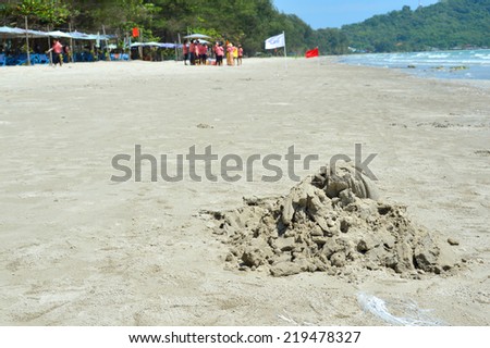 RAYONG - SEPTEMBER 20 : Construction pile of sand and group of students are playing games on Mae Ram Pung beach on September 20, 2014 in Rayong, Thailand.