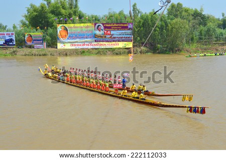 MAHASARAKHAM - OCTOBER 7 : Oarsmen are rowing while women are dancing in old traditional long boats competition at Chi river of Tha Toom village on October 7, 2014 in Mahasarakham, Thailand.