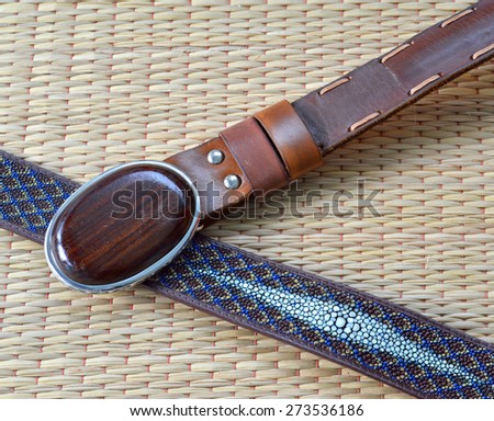 stingray skin belt and leather belt with Siamese Rosewood buckle on a mat