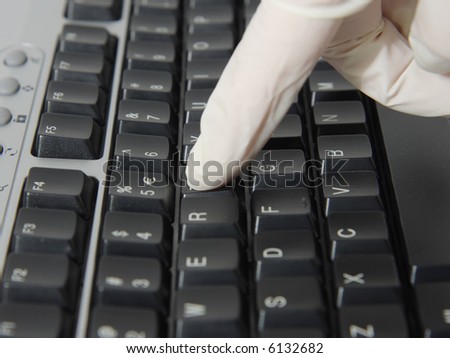 Infection control. Woman in the latex gloves typing on a computer keyboard.