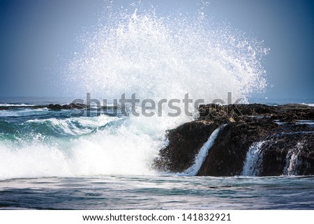 Pure Blue Waters Of California\'s Pacific Ocean, Coastal Waves Breaking And Splashing On Sea Coast Rocks Encrusted With Mussels