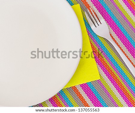 Beige ceramic plate, napkin and fork for food presentation