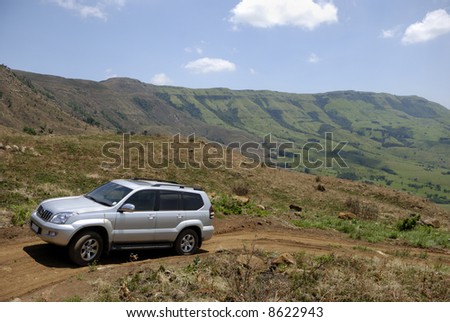 a 4x4 Vehicle driving on a dirt road leading up the Drakensberg Mountain Range, KZN, South Africa