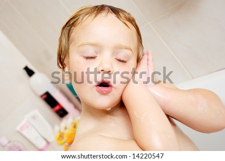 stock photo Image of a child having fun in the bath tub with a cute