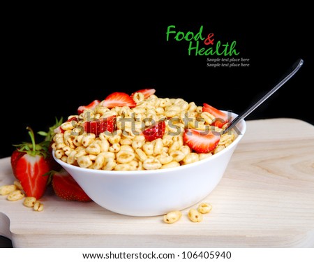 Fresh corn flakes with strawberries close up isolated on black