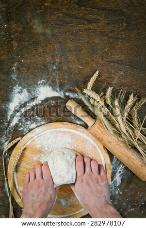 Making dough by mens hands on wooden table background