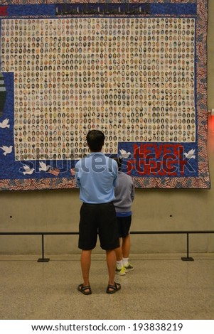 NEW YORK CITY, USA - May 17, 2014: People looking at a quilt in the National 9/11 Memorial Museum at Ground Zero in Lower Manhattan.